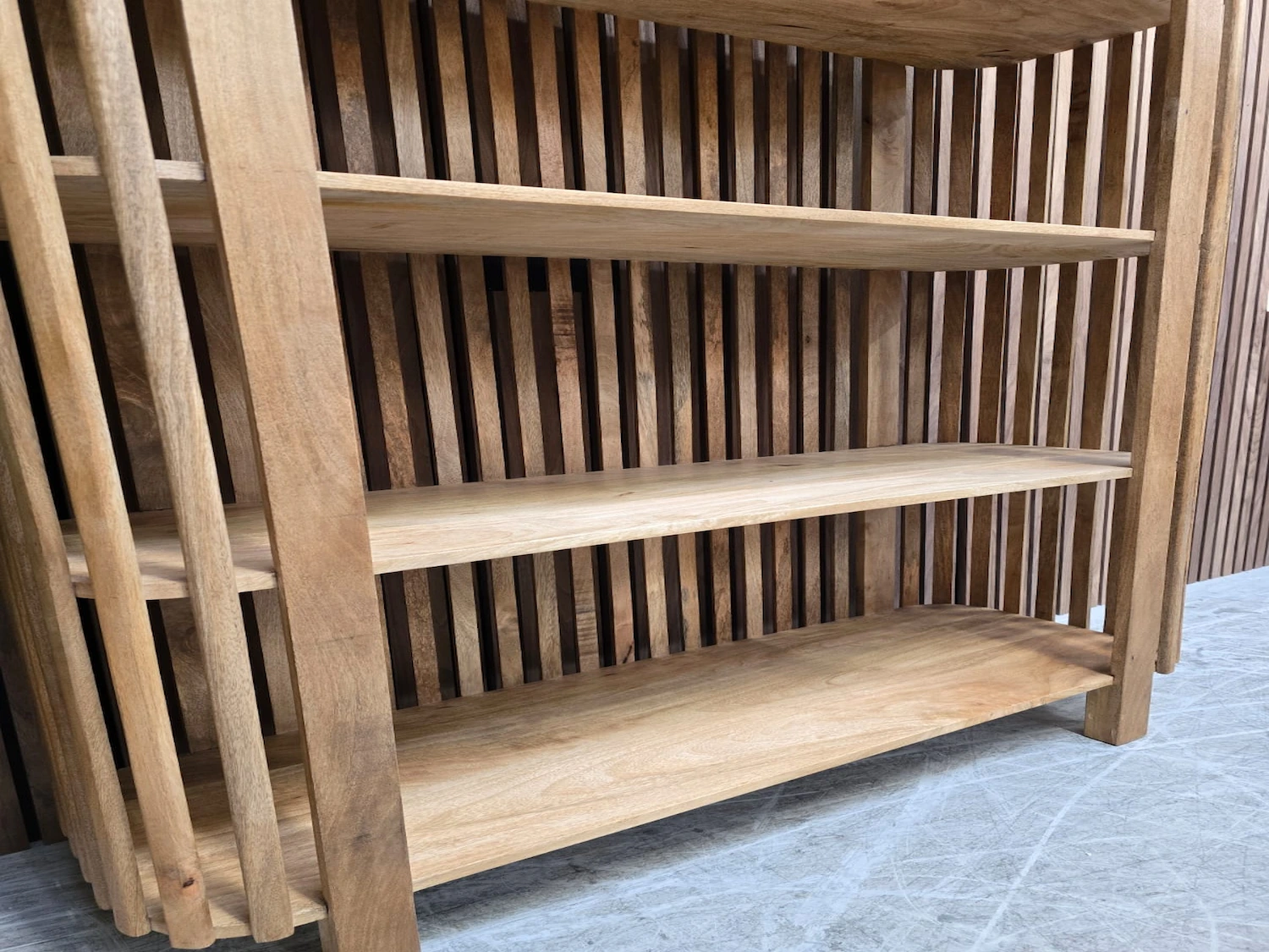 the bottom shelves on the bookshelf in light mango wood