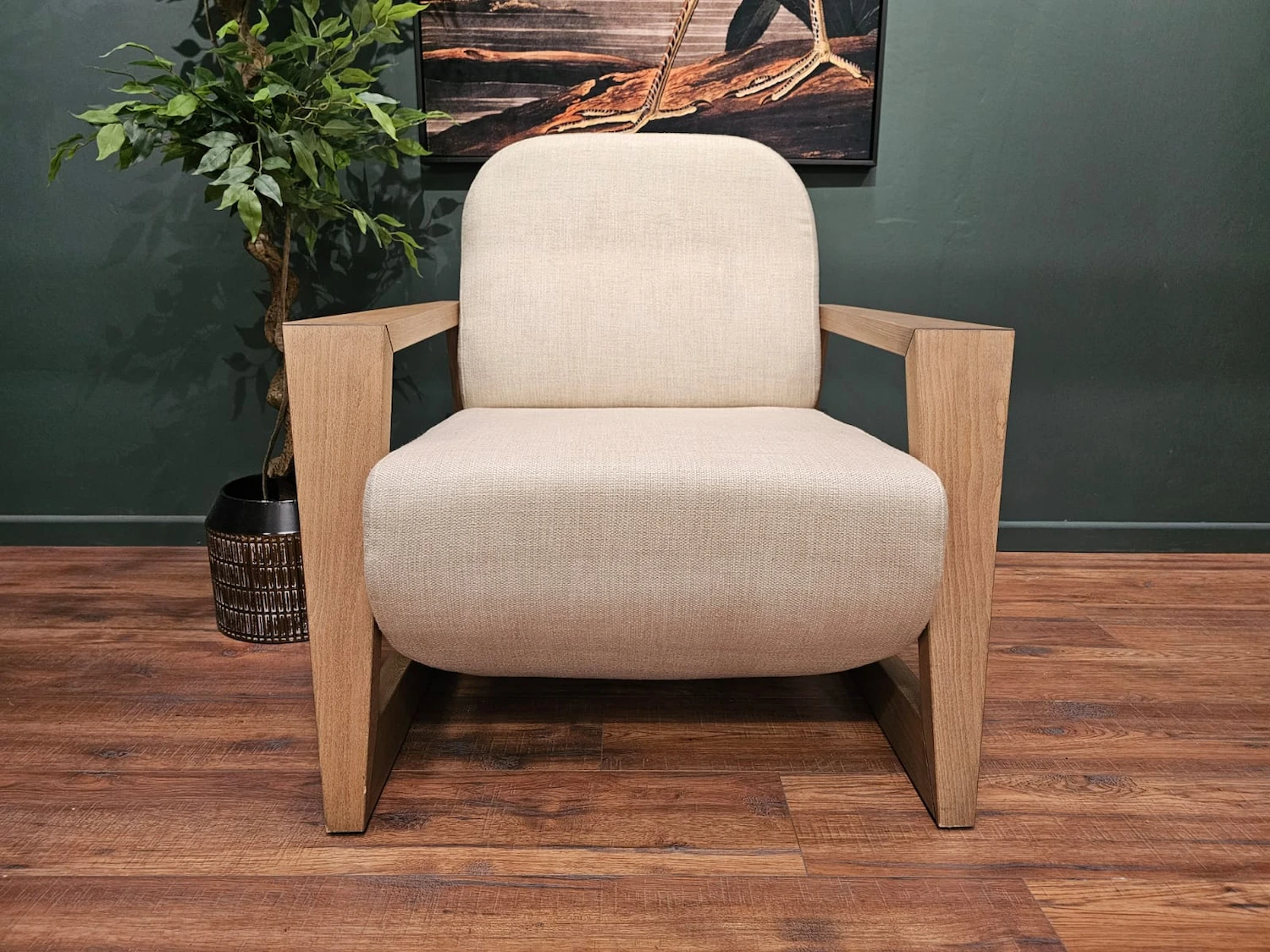 a light coloured chair with woodern arms and legs